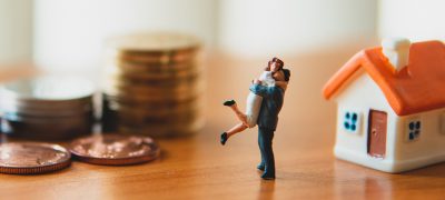 Miniature,People„Husband,And,Wife,Standing,With,Stack,Coins,Background Miniature people, husband and wife standing with stack coins background using as business and family concept